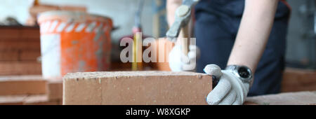 Skilled bricklayer putting red block Stock Photo