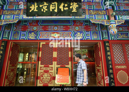 --FILE--A pedestrian walks past a branch of Beijing Tongrentang (TRT), a time-honored Traditional Chinese Medicine brand since 1669, in Shanghai, Chin Stock Photo