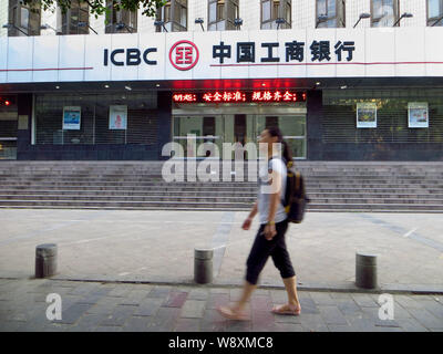 --FILE--A pedestrian walks past a branch of ICBC (Industrial and Commercial Bank of China) in Yichang city, central Chinas Hubei province, 30 July 201 Stock Photo