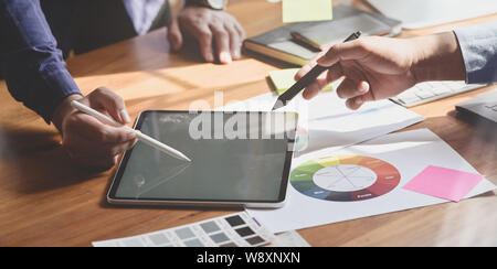 Cropped view of graphic designer team working on their upcoming project with tablet Stock Photo