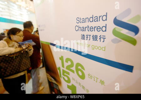 --FILE--People visit the stand of Standard Chartered bank at an expo in Shanghai, China, 23 November 2012.   Standard Chartered has agreed to sell its Stock Photo