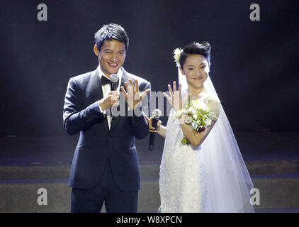 American actor Archie Kao, left, and Chinese actress Zhou Xun in a white wedding dress show their engagement rings after announcing their wedding duri Stock Photo