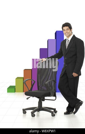 Businessman standing in front of bar graph rising upward Stock Photo