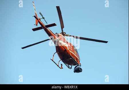 A helicopter flies to film scenes during a filming session for the movie, Transformers 4: Age of Extinction, at the Three Natural Bridges scenic spot Stock Photo