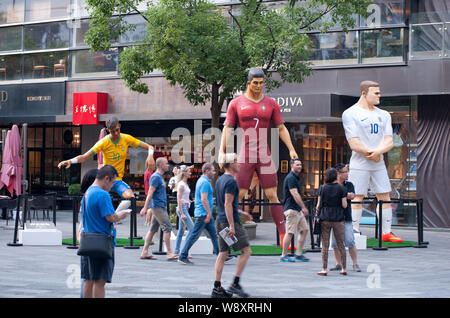 Visitors walk past three giant figures of football superstars (from left) Neymar of Brazil, Cristiano Ronaldo of Portugal and Wayne Rooney of England Stock Photo