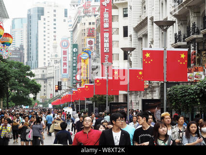 Tourists crowd the Nanjing Road shopping street to celebrate the National Day holiday in Shanghai, China, 30 September 2014. Stock Photo