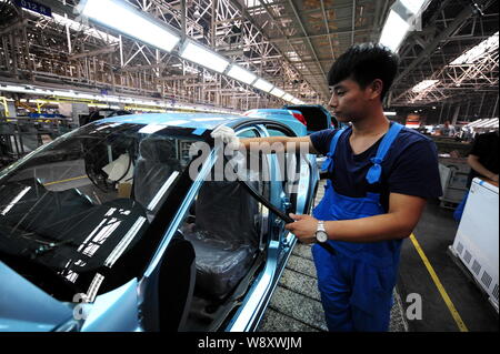 --FILE--A Chinese worker assembles a car on the assembly line at an ...
