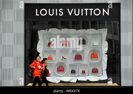 FILE--Pedestrians walk past the fashion boutique of Louis Vuitton