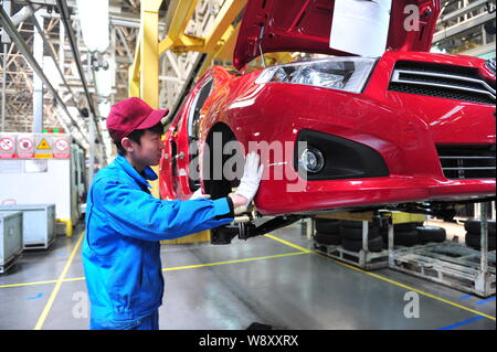 --FILE--A Chinese worker assembles a car on the assembly line at an ...