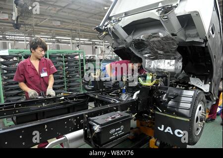 --FILE--Chinese workers assemble a truck on the assembly line at the ...