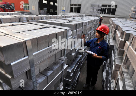 --FILE--A Chinese worker checks aluminium bars at a factory in Zouping county, east Chinas Shandong province, 20 August 2014.      Growth in China's l Stock Photo