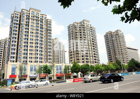 --FILE--Cars pass by new residential apartment buildings in Rizhao city, east China's Shandong province, 14 August 2014.   Property launches in China Stock Photo