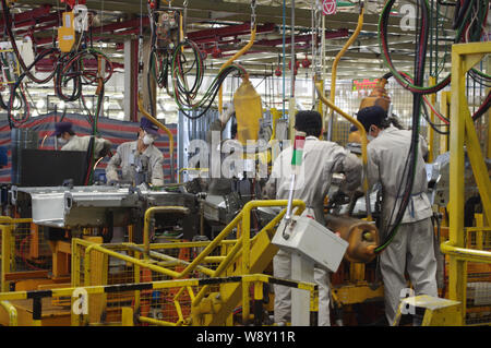 --FILE--Chinese factory workers prepare parts on the assembly line at an auto plant of Dongfeng Motor Corporation in Wuhan city, central Chinas Hubei Stock Photo