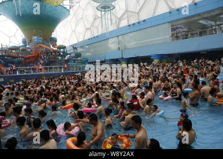 --FILE--Holidaymakers crowd a swimming pool to cool down in an indoor water park at the National Aquatics Center, also known as the Water Cube, in Bei Stock Photo