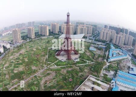 The downsized replication of Eiffel Tower is surrounded by vegetable fields and residential apartment buildings in Tianducheng, a small Chinese commun Stock Photo