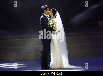 American actor Archie Kao, left, and Chinese actress Zhou Xun in a white wedding dress kiss after announcing their wedding during the One Night charit Stock Photo