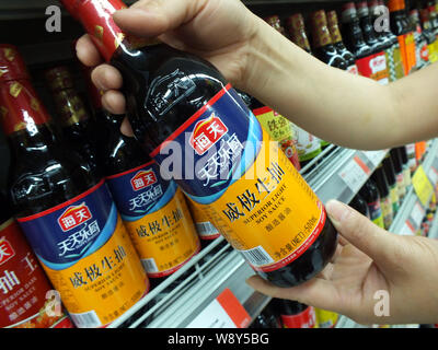 --FILE--A customer buys a bottle of Haitian superior light soy sauce of Foshan Haitian Flavouring and Food Co. at a supermarket in Yichang, central Ch Stock Photo