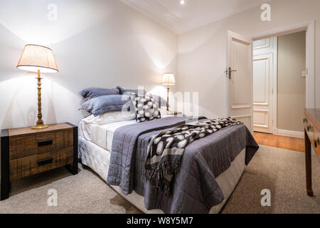 Luxury bedroom in a domestic home decorated with side lights, bed side tables - carpeted Stock Photo