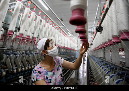 --FILE--A female Chinese worker handles production of yarn to be exported to Europe at a textile factory in Huaibei city, east Chinas Anhui province, Stock Photo