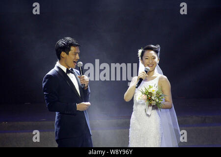American actor Archie Kao, left, speaks as Chinese actress Zhou Xun in a white wedding dress laughs after announcing their wedding during the One Nigh Stock Photo