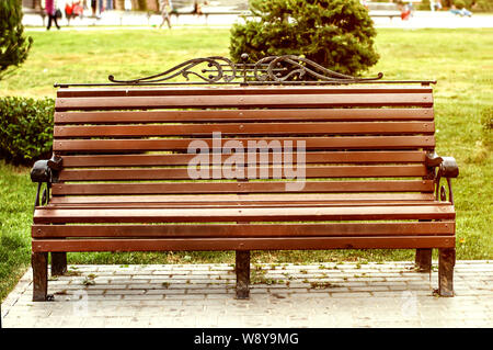 Wooden bench in city park in summer. Stock Photo