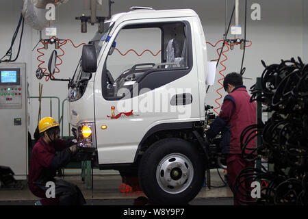 --FILE--Chinese workers assemble a truck on the assembly line at the ...