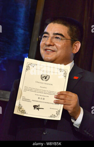 --FILE--Chinese billionaire philanthropist Chen Guangbiao, Chairman of Jiangsu Huangpu Recycling Resources Co., Ltd., displays a certificate issued by Stock Photo