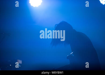 Silhouette of a guitarist in blue stage lights Stock Photo