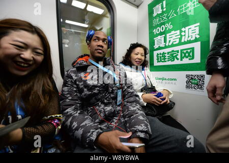 Former NBA star Stephon Marbury of Beijing Ducks Basketball Club, center, takes a subway train of the Beijing Metro Line 1 in Beijing, China, 8 Decemb Stock Photo