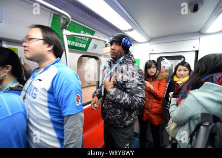 Former NBA star Stephon Marbury of Beijing Ducks Basketball Club, center, takes a subway train of the Beijing Metro Line 1 in Beijing, China, 8 Decemb Stock Photo