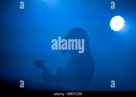 Silhouette of a guitarist in blue stage lights Stock Photo
