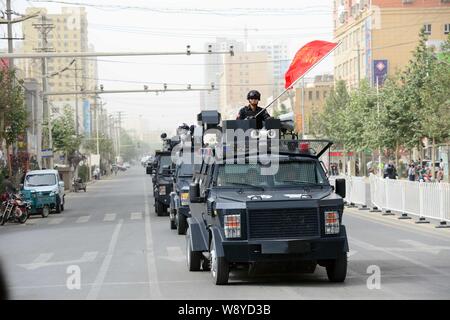 SWAT police officers armed with guns stand on patrol vehicles during a city patrol in Hotan, northwest Chinas Xinjiang Uygur Autonomous Region, 6 June Stock Photo