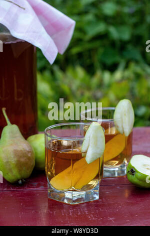 Homemade Fermented Raw Kombucha Tea with Pears, Summer Healthy Detox Drink in jar and two glass, verticalal orientation Stock Photo