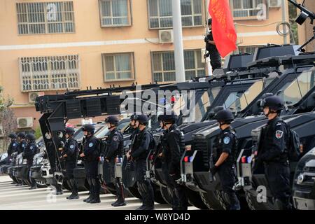 SWAT police officers armed with guns assemble during a city patrol in Hotan, northwest Chinas Xinjiang Uygur Autonomous Region, 6 June 2014.   Chinese Stock Photo