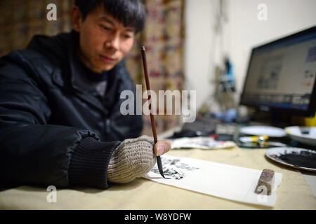 Chinese handicapped artist Zhang Qihui, who lost his left arm and four fingers on his right hand in an accident, makes a painting at home in Chongqing Stock Photo