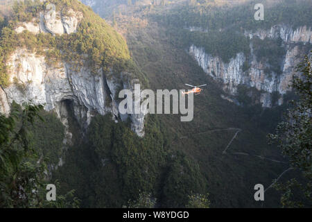 --FILE--A helicopter flies to film scenes during a filming session for the movie, Transformers: Age of Extinction, at the Three Natural Bridges scenic Stock Photo