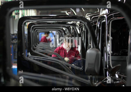 --FILE--A female Chinese worker assembles a car on the assembly line at ...