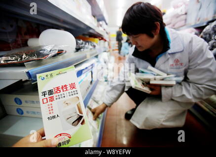 --FILE--A clerk puts face masks against PM2.5 on the shelf for sale at a pharmacy in Wuhan city, central Chinas Hubei province, 19 December 2013. Stock Photo