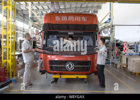 --FILE--Chinese workers assemble a truck on the assembly line at an ...