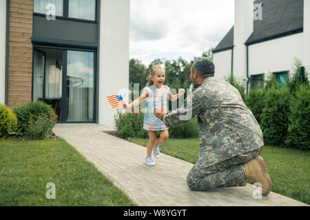 Military servant meeting his cute lovely girl near the house Stock Photo