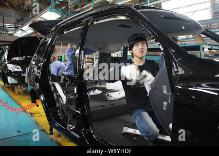 --FILE--A Chinese worker assembles a FAW truck on the assembly line at ...
