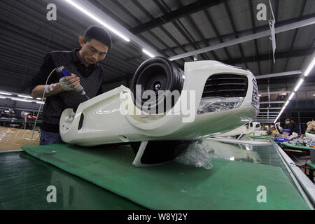 --FILE--A Chinese worker assembles a car on the assembly line at an ...