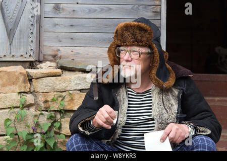 Portrait of old man smoking a cigarette in Siberia Stock Photo