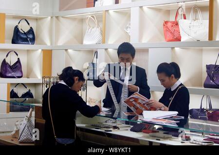 FILE--Customers shop for Louis Vuitton (LV) bags and other