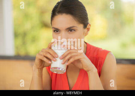 Woman feeling thoughtful while drinking milk for breakfast Stock Photo