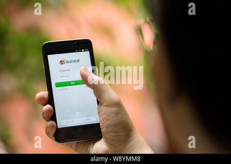 --FILE--A Chinese woman uses Weibo, the Twitter-like microblogging service of Sina, on her smartphone in Guangzhou city, south Chinas Guangdong provin Stock Photo