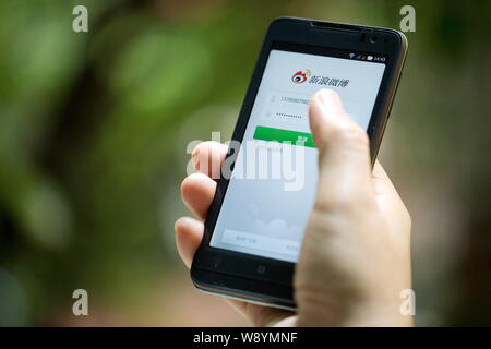 --FILE--A Chinese woman uses Weibo, the Twitter-like microblogging service of Sina, on her smartphone in Guangzhou city, south Chinas Guangdong provin Stock Photo