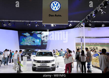 --FILE--Visitors look at a Volkswagen Tiguan SUV and other cars at the stand of Shanghai Volkswagen, a joint venture between SAIC and VW, during an au Stock Photo