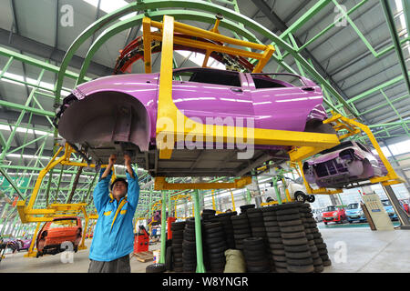 --FILE--A Chinese worker assembles a car on the assembly line at an ...