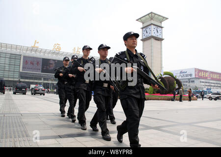 Police officers armed with guns patrol at the square of the Shanghai Railway Station in Shanghai, China, 14 May 2014.   SWAT police and other armed of Stock Photo